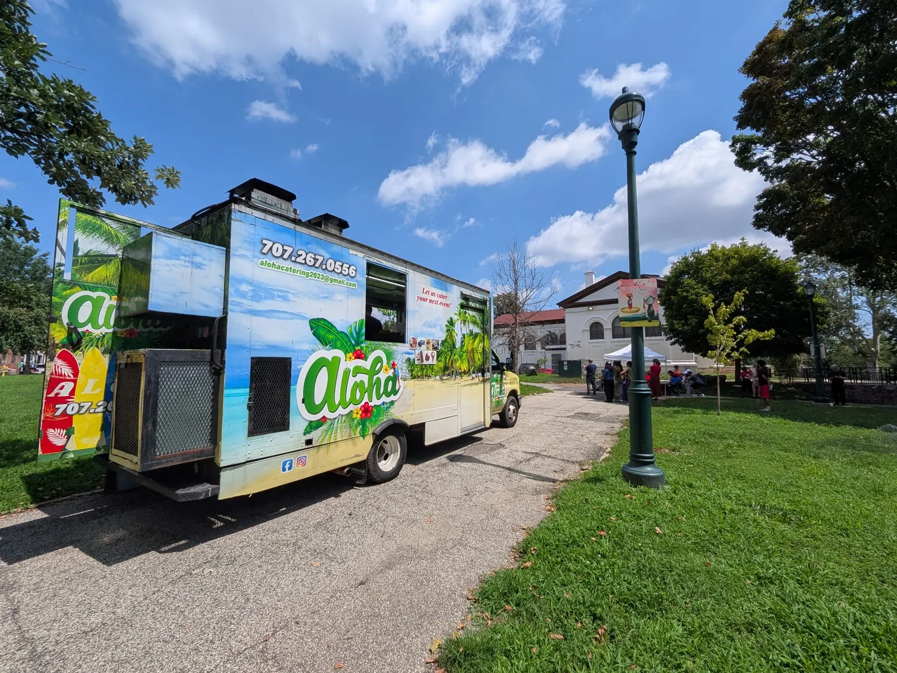 The tropical-liveried Aloha truck parked on a street corner beside a lamppost