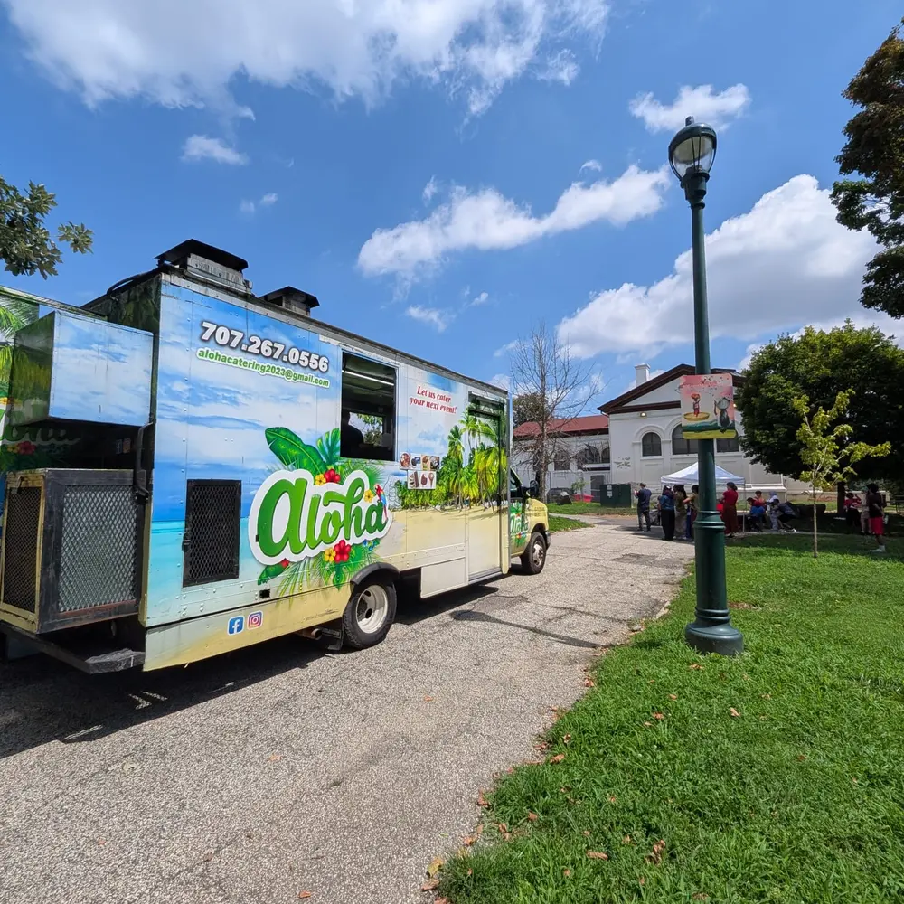 The Aloha truck parked on a quiet street corner beside an old-fashioned lamppost