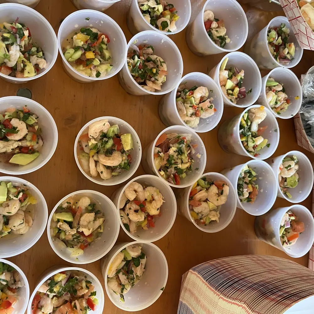 Individual shrimp and avocado appetizer cups arranged for a catered event